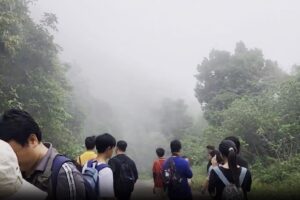 Clouds flowed down the mountain, creating a magical scene as the group prepared to leave.
