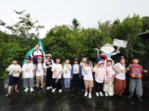 Students taking a commemorative photo at Vong Canh Hill on a rainy afternoon in Son Tra.